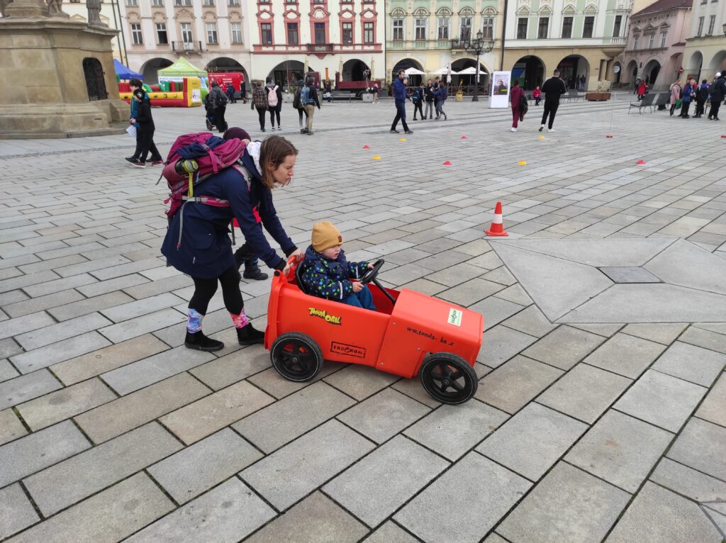 Fotografie z Dne Země 18.04.2023 na náměstí - dítě v autíčku z plastové popelnice