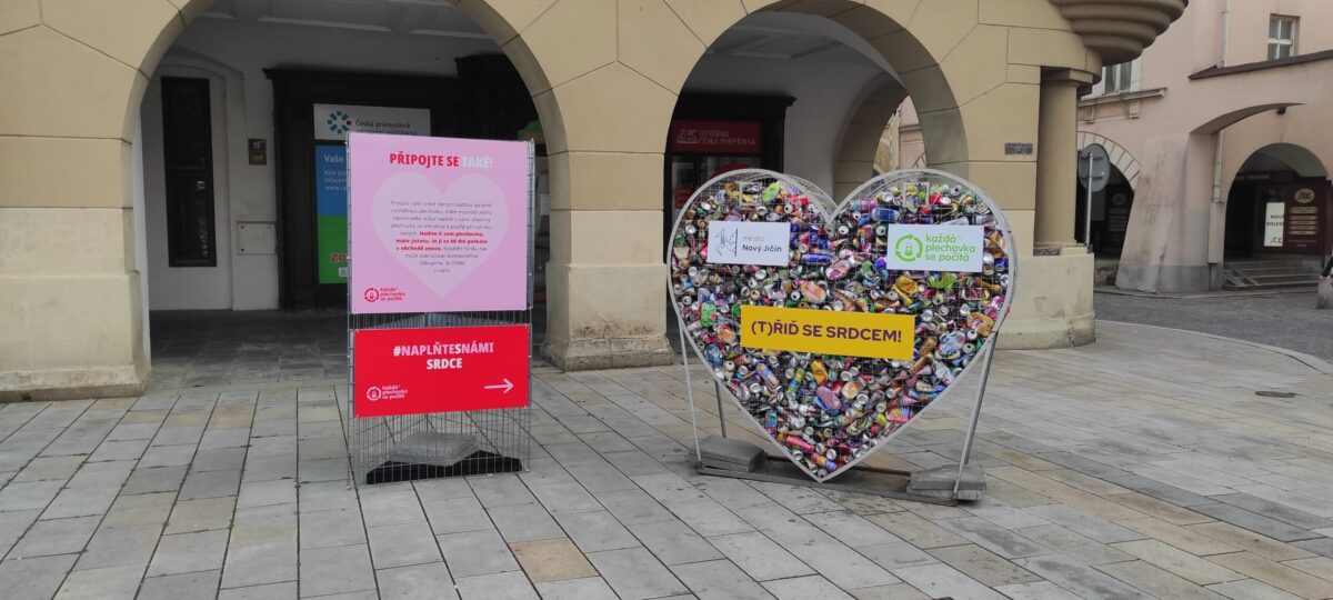 Foto konstrukce ve tvaru srdce, která je vyplněna nasbíranými plechovkami